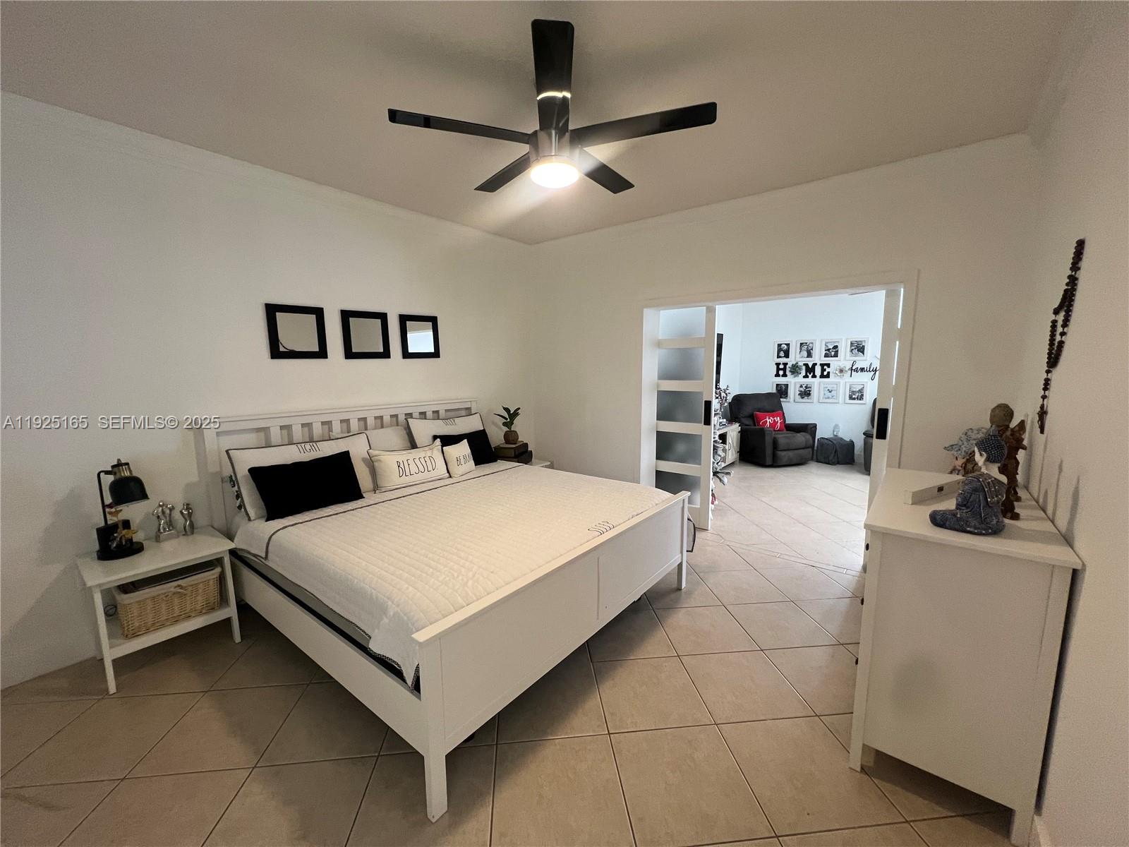 12446 Southwest 198th Street Miami, FL 33177 - Photo 45 of 56 a bedroom with a bed a couch and a chandelier