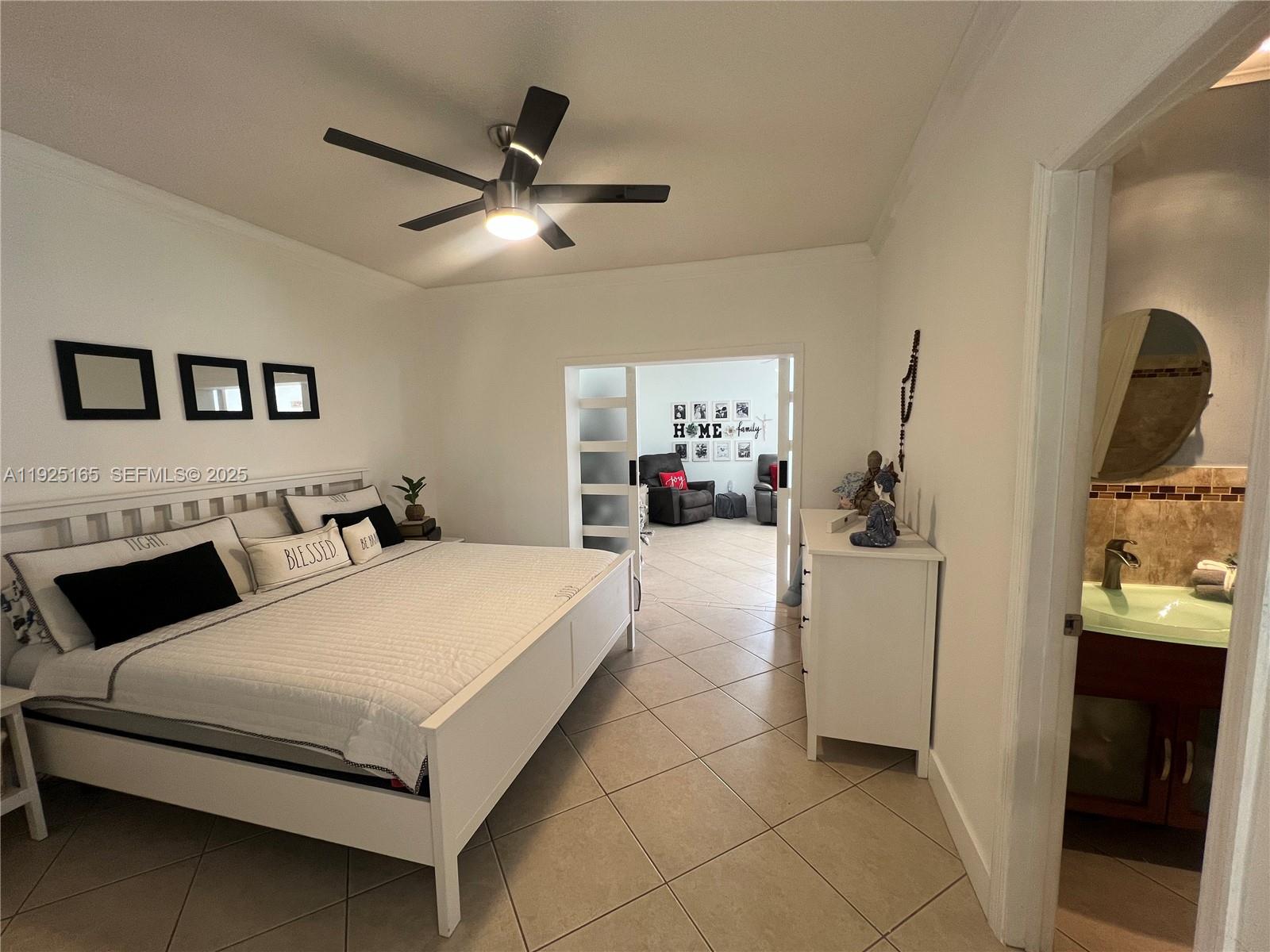 12446 Southwest 198th Street Miami, FL 33177 - Photo 48 of 56 a spacious bedroom with a bed and a chandelier