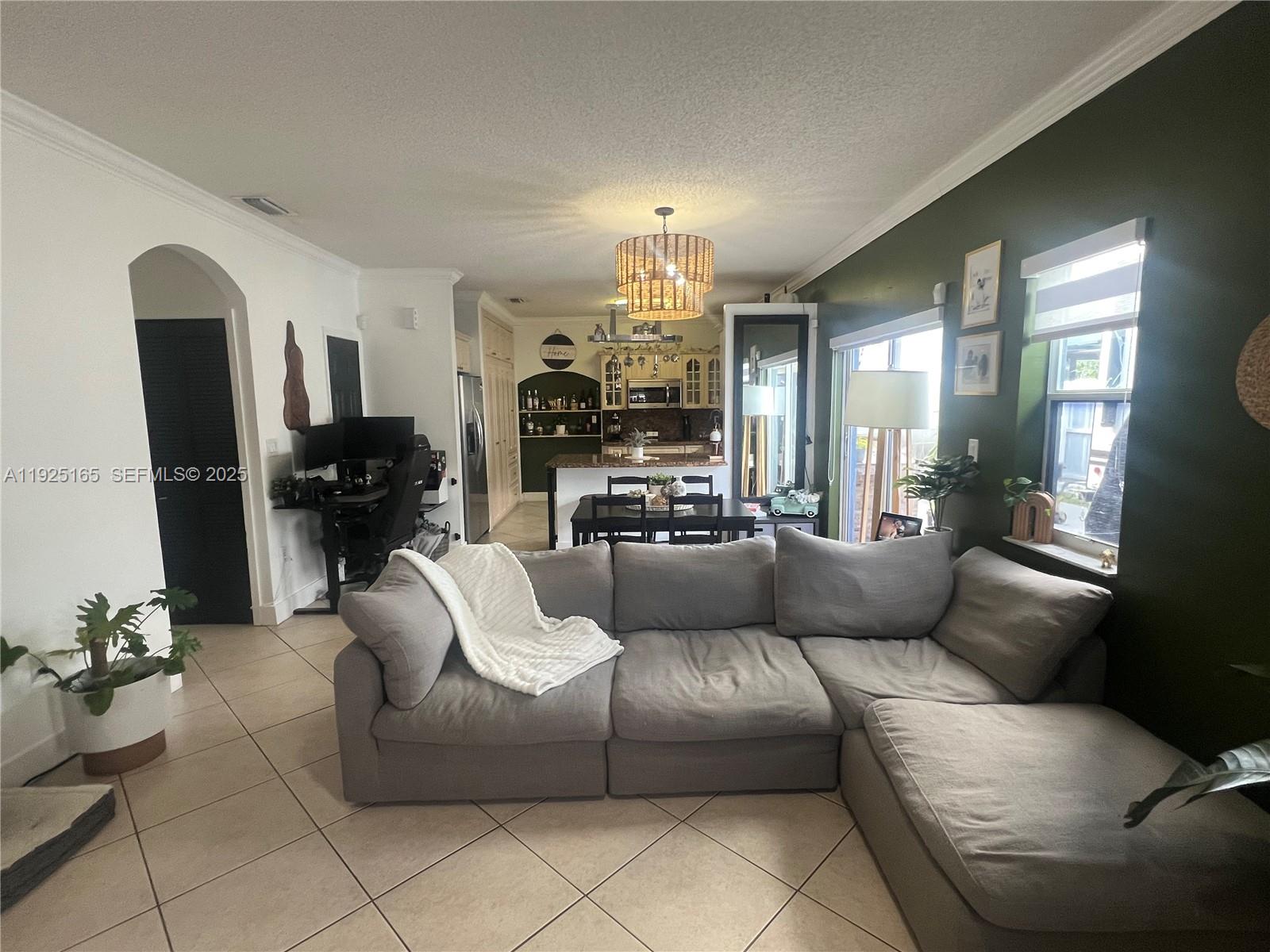 12446 Southwest 198th Street Miami, FL 33177 - Photo 10 of 56 a living room with furniture and a chandelier