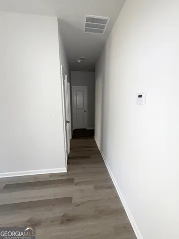 a view of a hallway with wooden floor