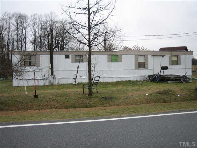 Live Oak Road Coats, NC 27521 - Photo 3 of 4 a view of a white house next to a yard with big trees
