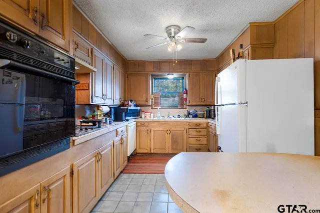 a kitchen with refrigerator a stove a sink and cabinets