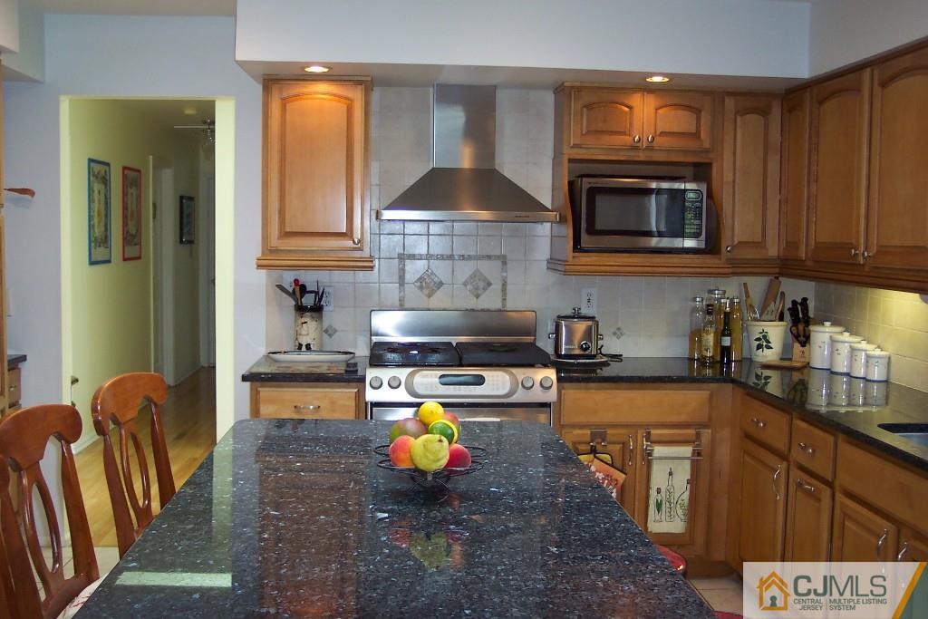 208 Normandy Road Edison, NJ 08820 - Photo 14 of 25 a kitchen with stainless steel appliances granite countertop a stove a sink and a microwave