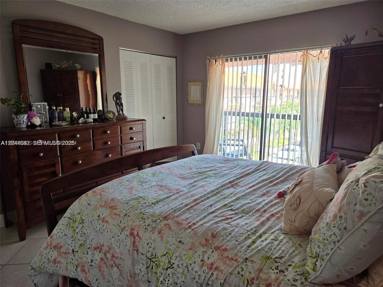 2174 West 60th Street, Unit 17205 Hialeah, FL 33016 - Photo 8 of 11 a bedroom with a bed and a large mirror on dresser