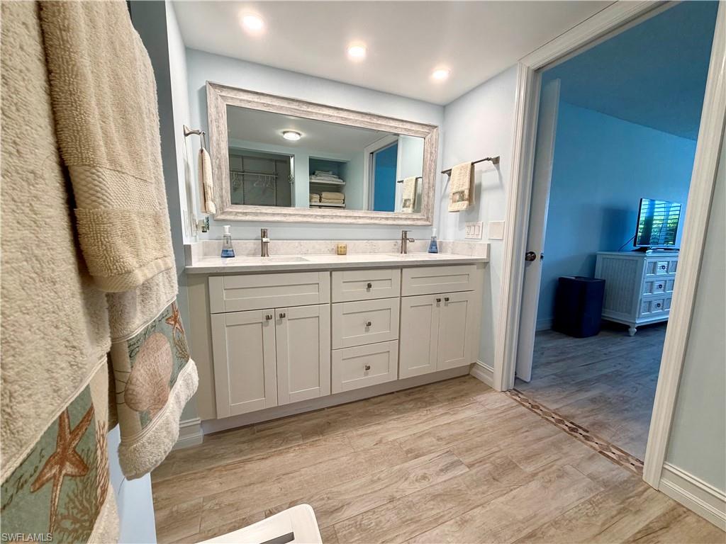105 Penny Lane, Unit 5 Naples, FL 34112 - Photo 11 of 15 a spacious bathroom with a granite countertop sink a toilet and a mirror