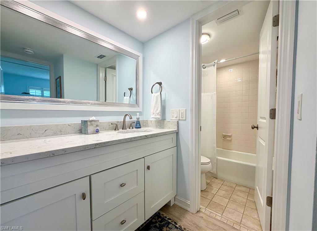 105 Penny Lane, Unit 5 Naples, FL 34112 - Photo 12 of 15 a bathroom with a sink a toilet and a mirror