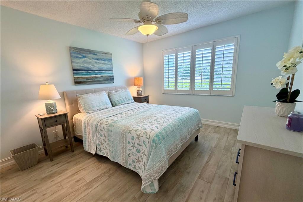 105 Penny Lane, Unit 5 Naples, FL 34112 - Photo 13 of 15 a bedroom with a bed and a table in it with window