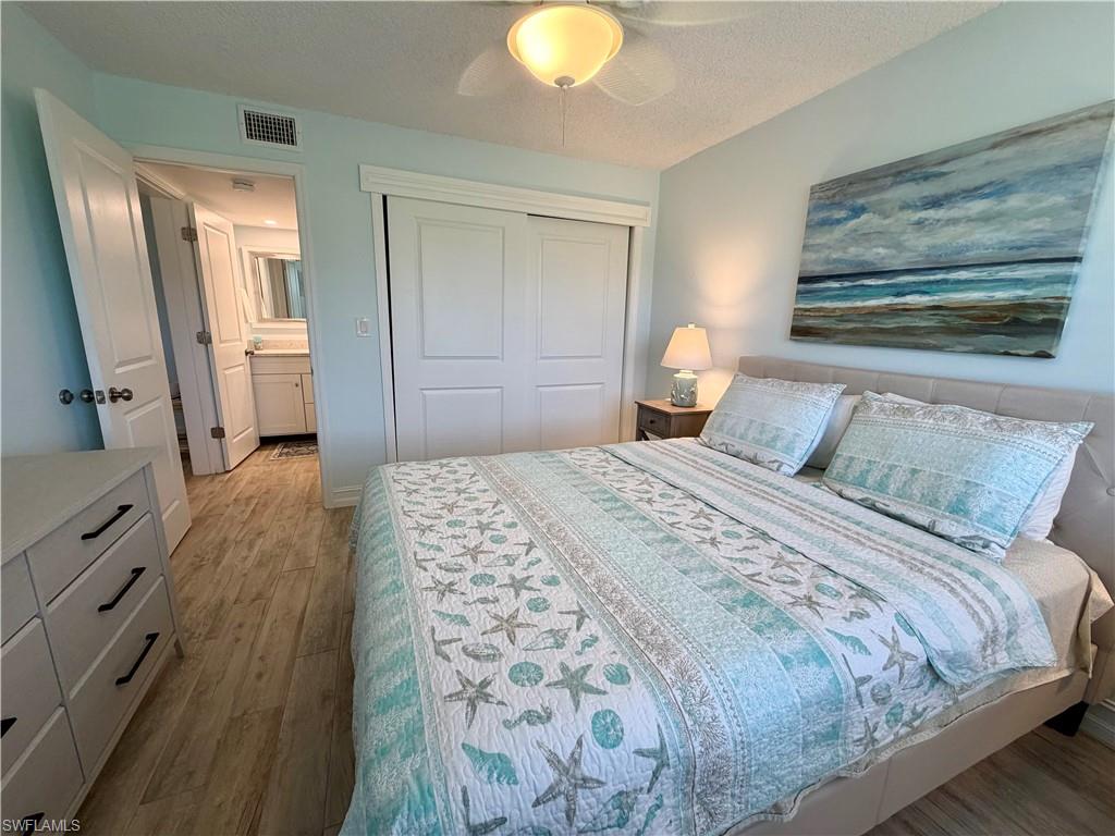 105 Penny Lane, Unit 5 Naples, FL 34112 - Photo 14 of 15 a bedroom with a bed and a chandelier