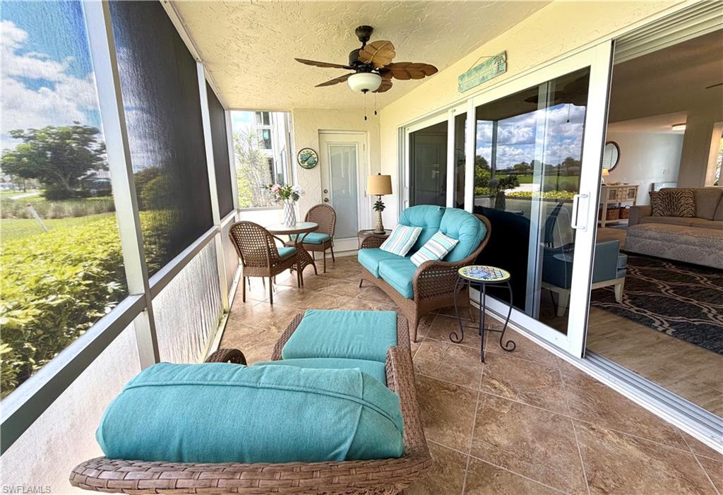 105 Penny Lane, Unit 5 Naples, FL 34112 - Photo 15 of 15 a living room with furniture and a floor to ceiling window
