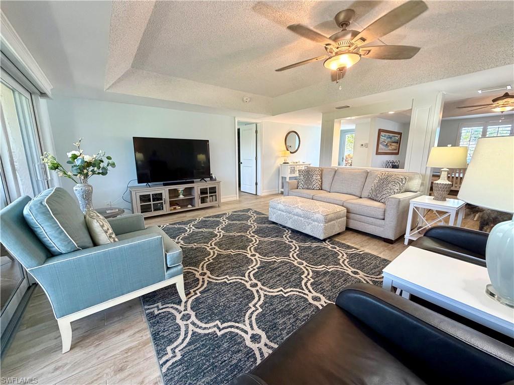 105 Penny Lane, Unit 5 Naples, FL 34112 - Photo 7 of 15 a living room with furniture and a flat screen tv