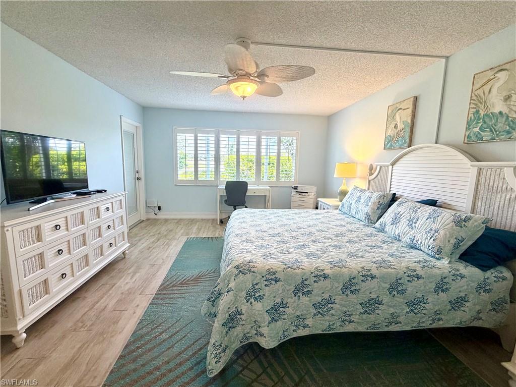 105 Penny Lane, Unit 5 Naples, FL 34112 - Photo 9 of 15 a bedroom with a bed and a flat screen tv on dresser