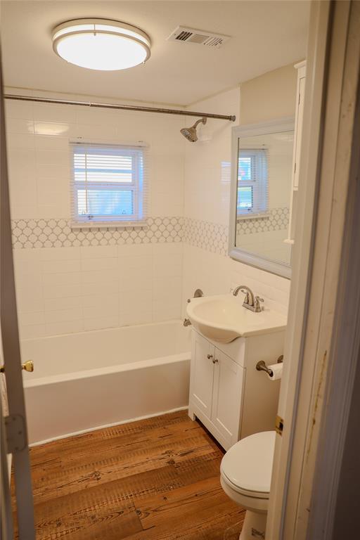 117 East Division Street Pilot Point, TX 76258 - Photo 6 of 19 Full bathroom featuring a white bathtub, wood-finish flooring, and a vanity with an integrated sink