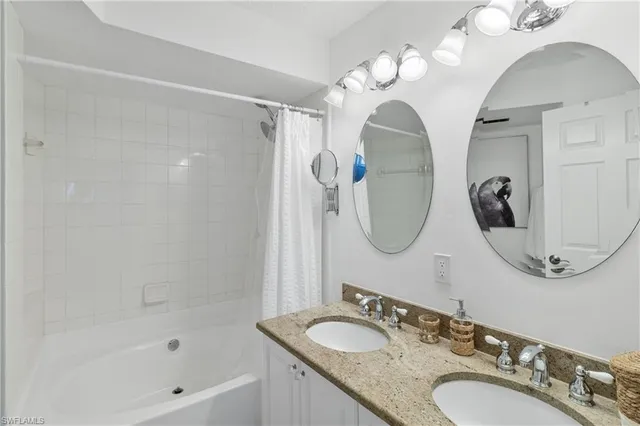 a bathroom with a granite countertop sink a mirror and a shower