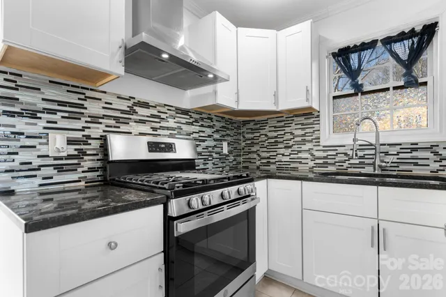 a kitchen with stainless steel appliances granite countertop a sink stove and cabinets