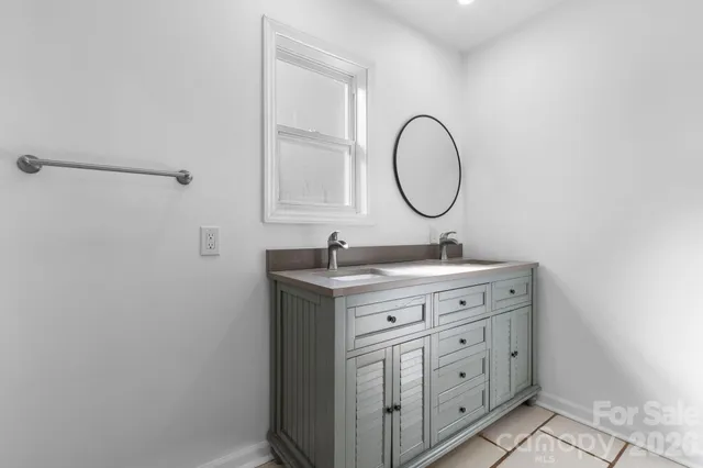 a bathroom with a granite countertop sink toilet and a mirror