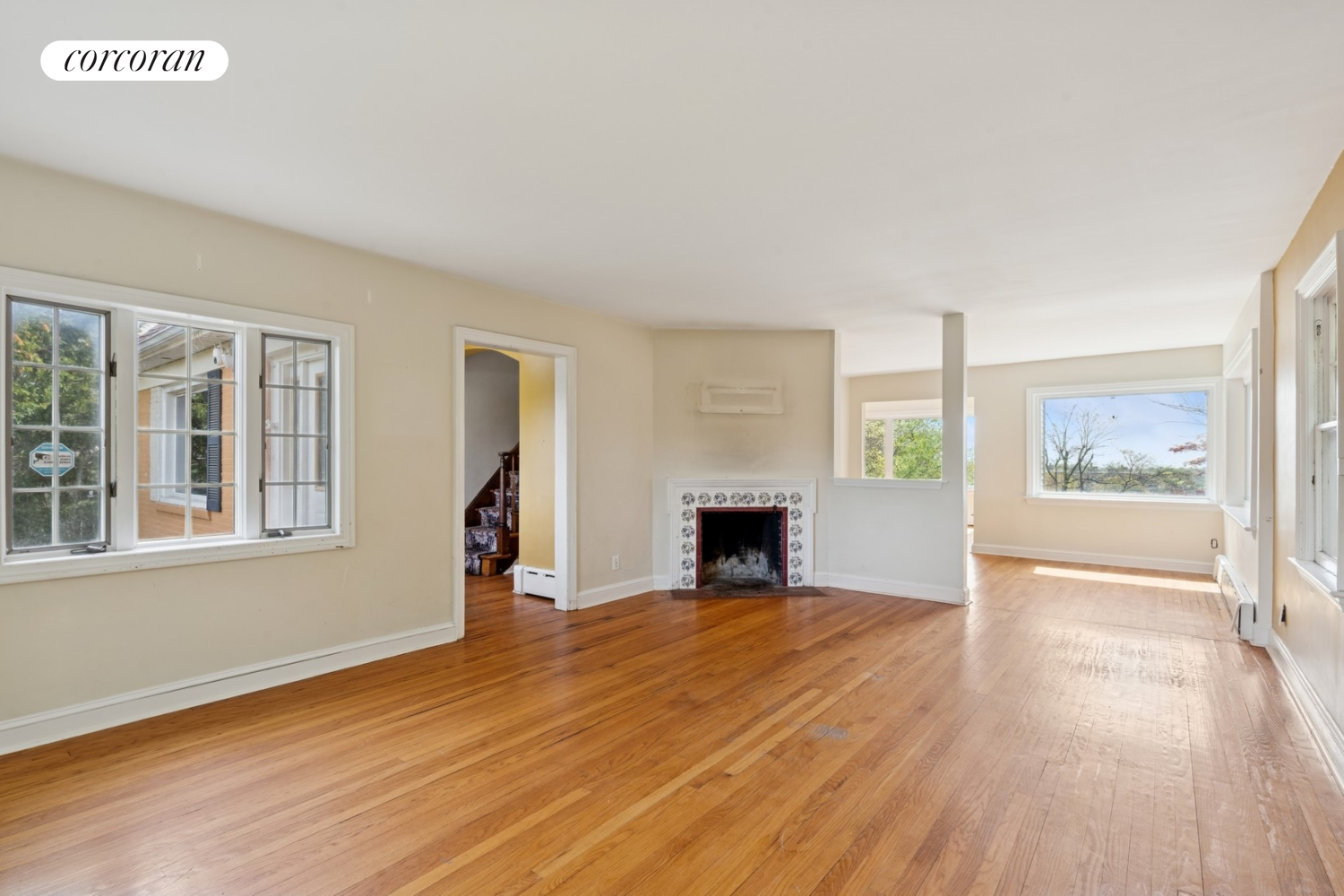 1197 Todt Hill Road Staten Island, NY 10304 - Photo 2 of 17 an empty room with wooden floor fireplace and windows
