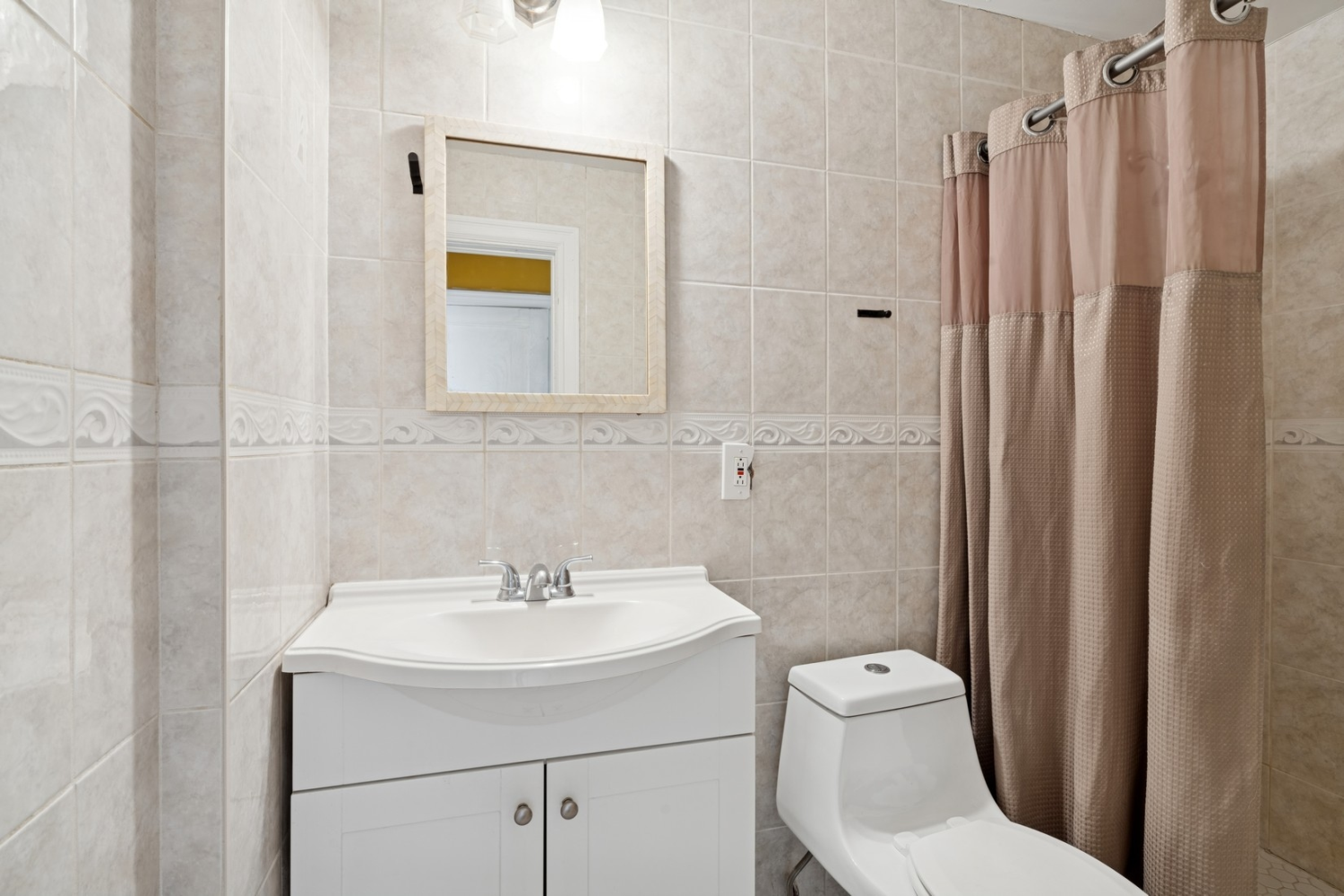 1197 Todt Hill Road Staten Island, NY 10304 - Photo 9 of 17 a bathroom with a sink a toilet and shower curtain