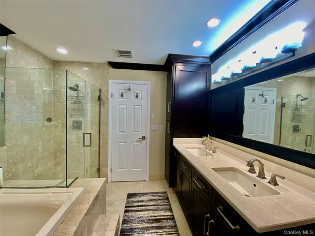 a bathroom with a double vanity sink mirror and shower
