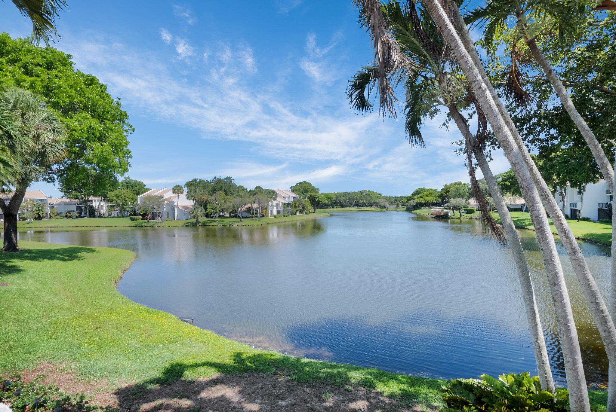 805 Bridgewood Place Boca Raton, FL 33434 - Photo 23 of 60 a view of a lake with a yard and large trees