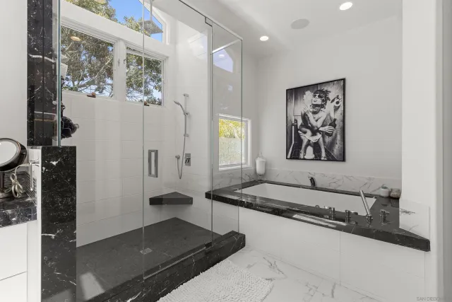 a spacious bathroom with a granite countertop sink a mirror and shower