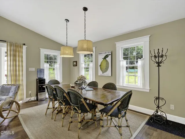 a view of a dining room and livingroom with furniture wooden floor a chandelier
