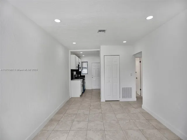 a view of a kitchen with refrigerator and white cabinets