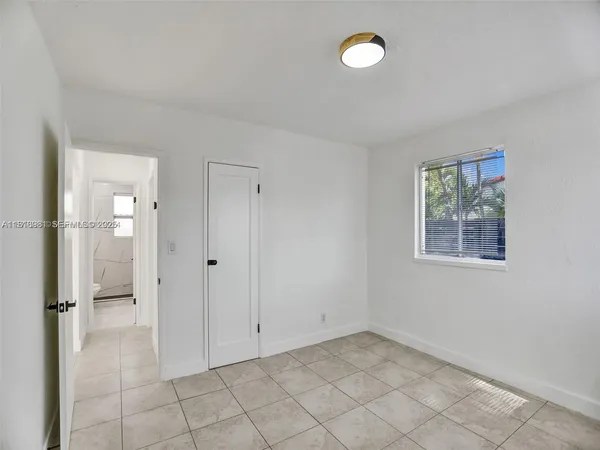 an empty room with windows and closet