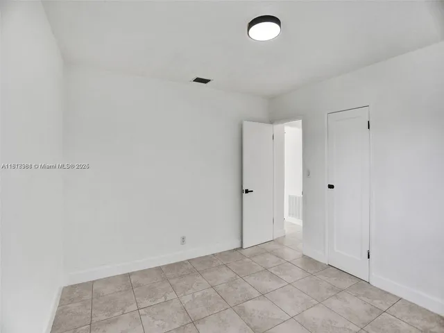 an empty room with windows and closet