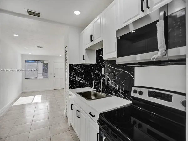 a kitchen with a sink and stainless steel appliances