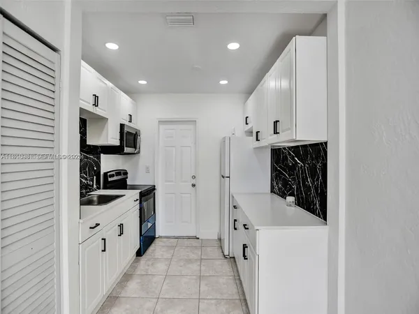 a kitchen with granite countertop a sink and stainless steel appliances