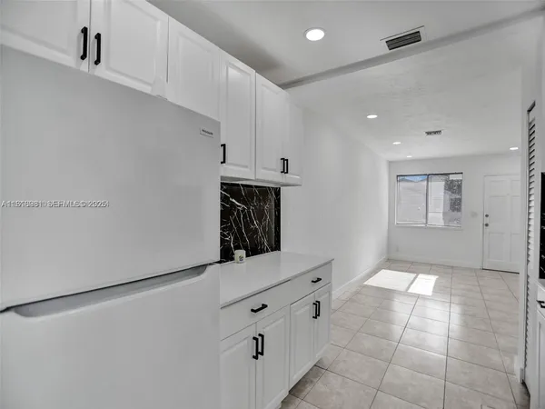 a kitchen with granite countertop white cabinets and white appliances