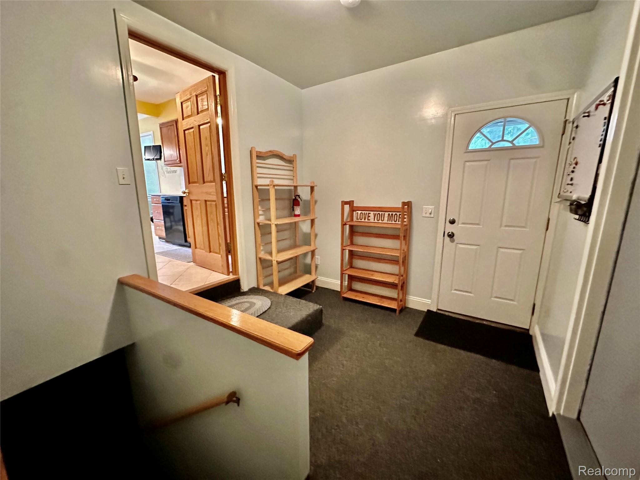 3404 Rockhaven Avenue Rochester, MI 48309 - Photo 12 of 19 Entryway with light gray walls, dark flooring, and a white front door featuring an arched decorative glass insert