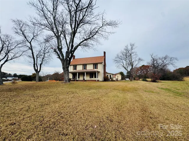 a front view of house with yard and ocean