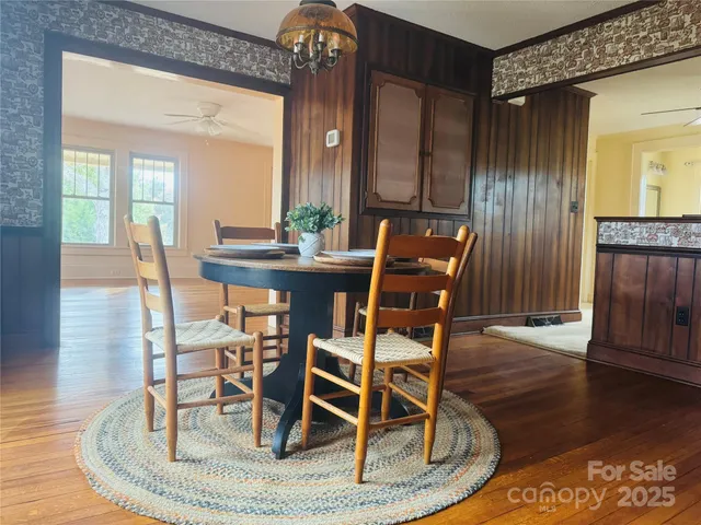 a dining room with wooden floor a glass table and chairs