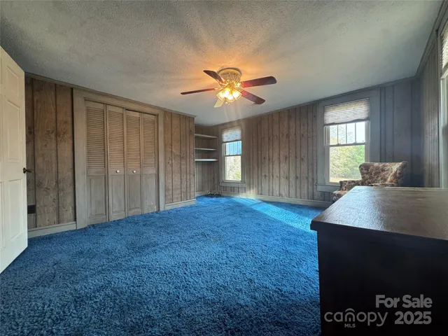 a view of a room with a ceiling fan and a window