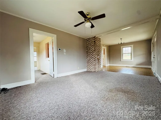 an empty room with fan and windows