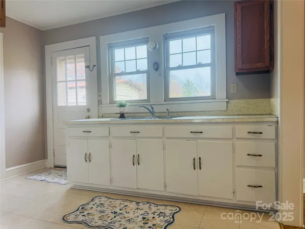 a room with granite countertop cabinets sink and window