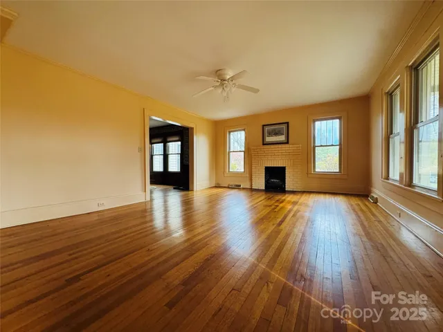 a view of a livingroom with wooden floor and a ceiling fan