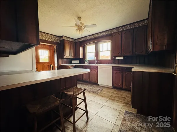 a kitchen with stainless steel appliances granite countertop wooden cabinets a stove a sink and a refrigerator