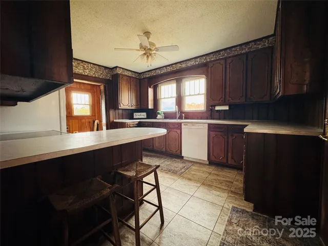 a kitchen with stainless steel appliances granite countertop wooden cabinets a stove a sink and a refrigerator