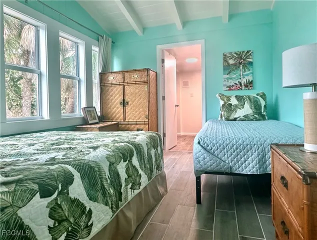 a bedroom with a bed and a lamp on dresser