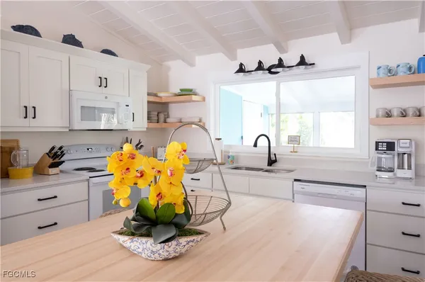 a view of a kitchen with kitchen island a counter space a sink and appliances