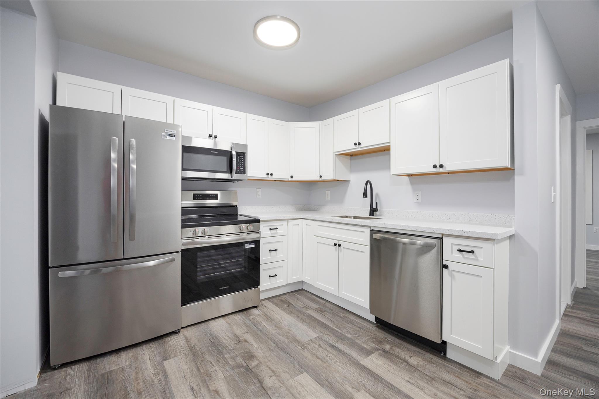 a kitchen with stainless steel appliances a refrigerator sink and microwave