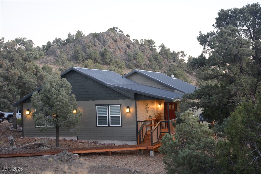 View of front of house featuring a deck with mountain view at Dusk
