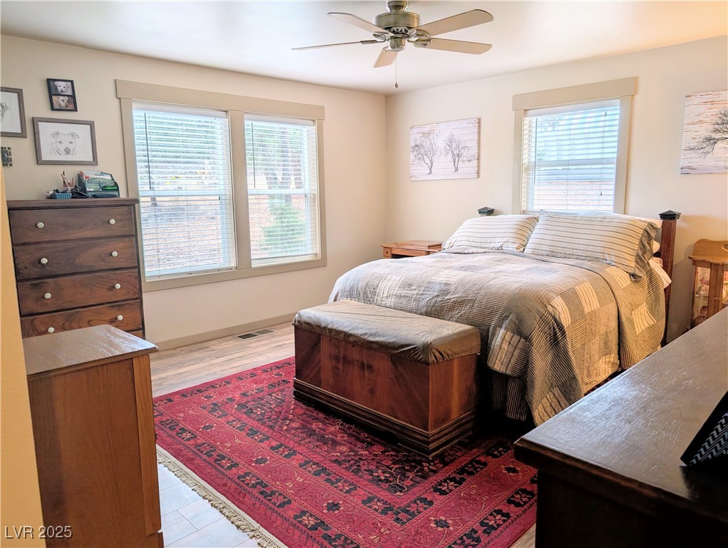 8320 Mother Lode Road Pioche, NV 89043 - Photo 32 of 46 Primary Bedroom with multiple windows, ceiling fan, and light wood floors