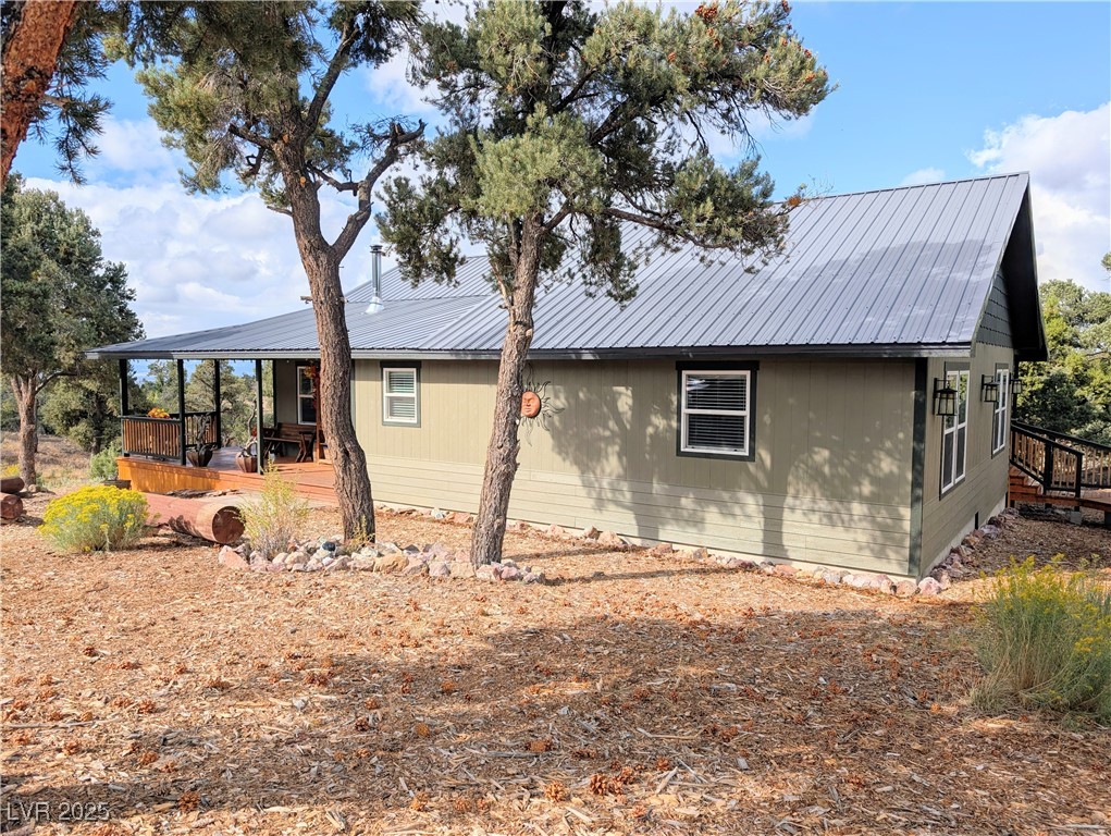 8320 Mother Lode Road Pioche, NV 89043 - Photo 5 of 46 View of side of property featuring a metal roof and a wooden deck
