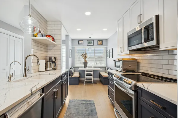 a kitchen with stainless steel appliances a stove sink microwave and cabinets