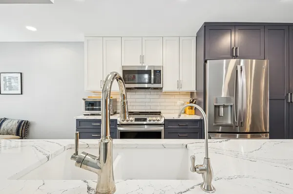 a kitchen with stainless steel appliances kitchen island granite countertop a refrigerator and a stove top oven