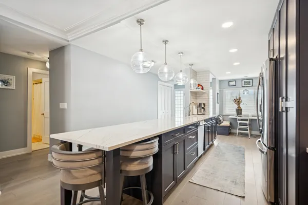 a kitchen with granite countertop a table chairs stove and a chandelier