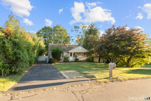 a front view of a house with a yard and trees